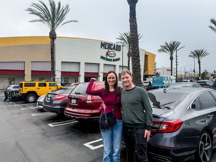 A couple poses near a market in California.