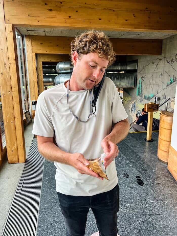 A man walks through the exhibits at La Maison du Gruyère while eating his cheese samples.