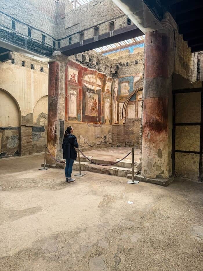 A woman poses at Roman ruins.