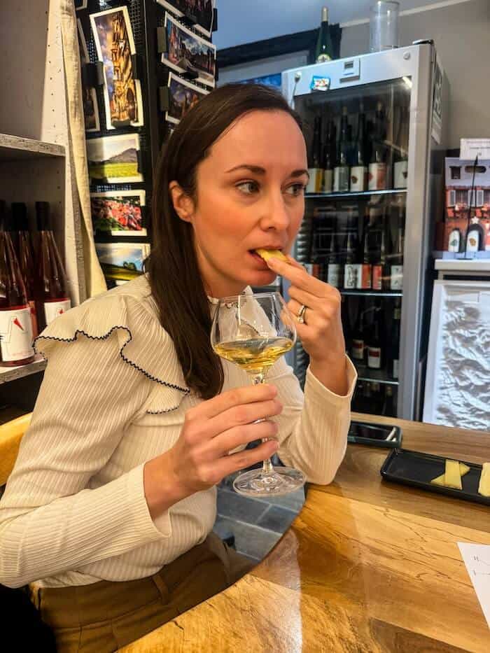 A woman drinking wine and enjoying some cheese.