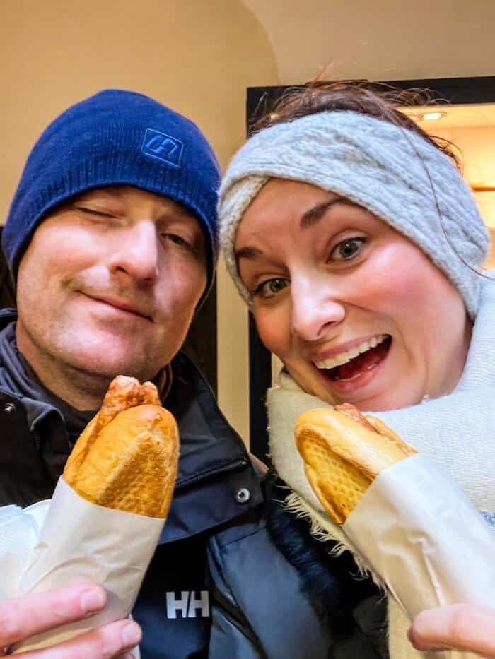 A couple poses with their sausages at Balkan Grill Walter in Salzburg.