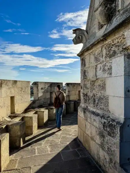 A woman walks around the top of the Lantern Tower in La Rochelle.