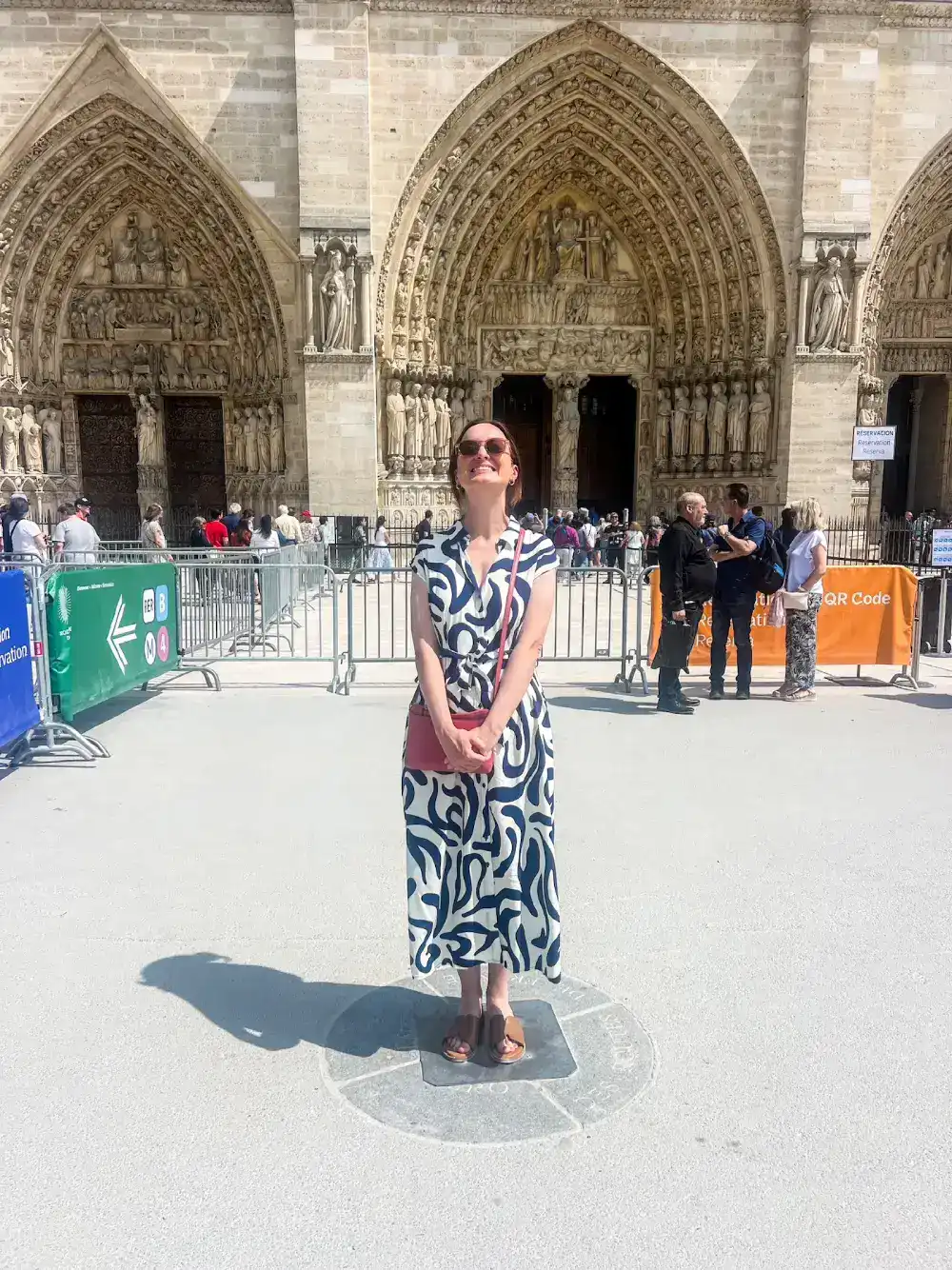 A woman poses outside of Notre Dame in Paris, France.
