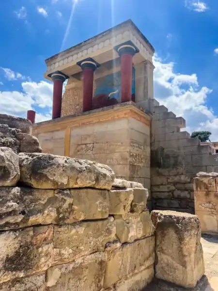 Red pillars and colorful frescoes at Knossos Palace in Crete