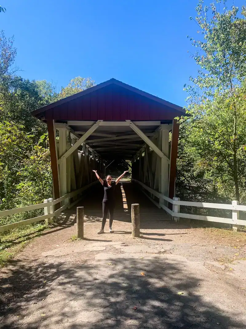 A woman poses near a covered bridge in Ohio.