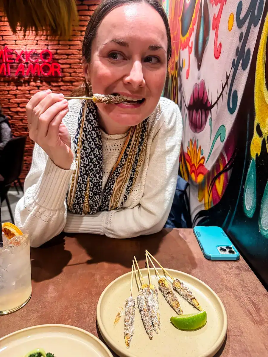 A woman eats baby corn at a taco shop in Malta.