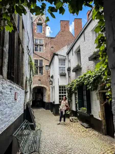 A woman poses on Vlaaikensgang in Antwerp, Belgium