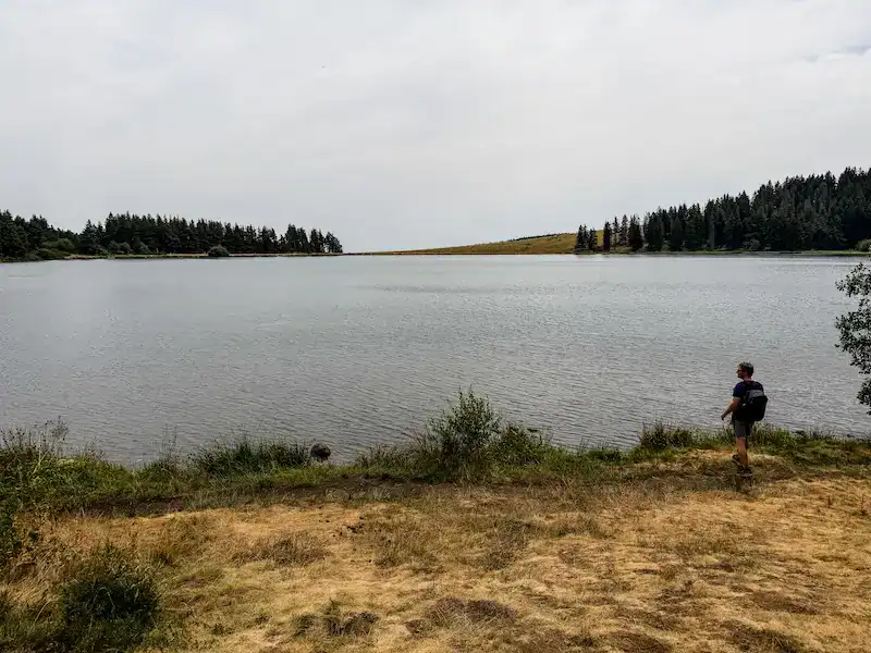 A man looks out on Lac de Servières near volcanoes in France.