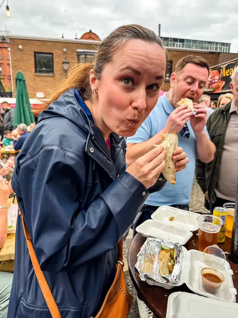 A woman eats at a food truck in Belfast.