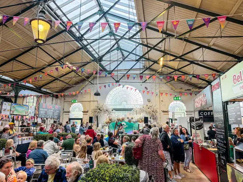 A group of people gather at a market in Belfast.