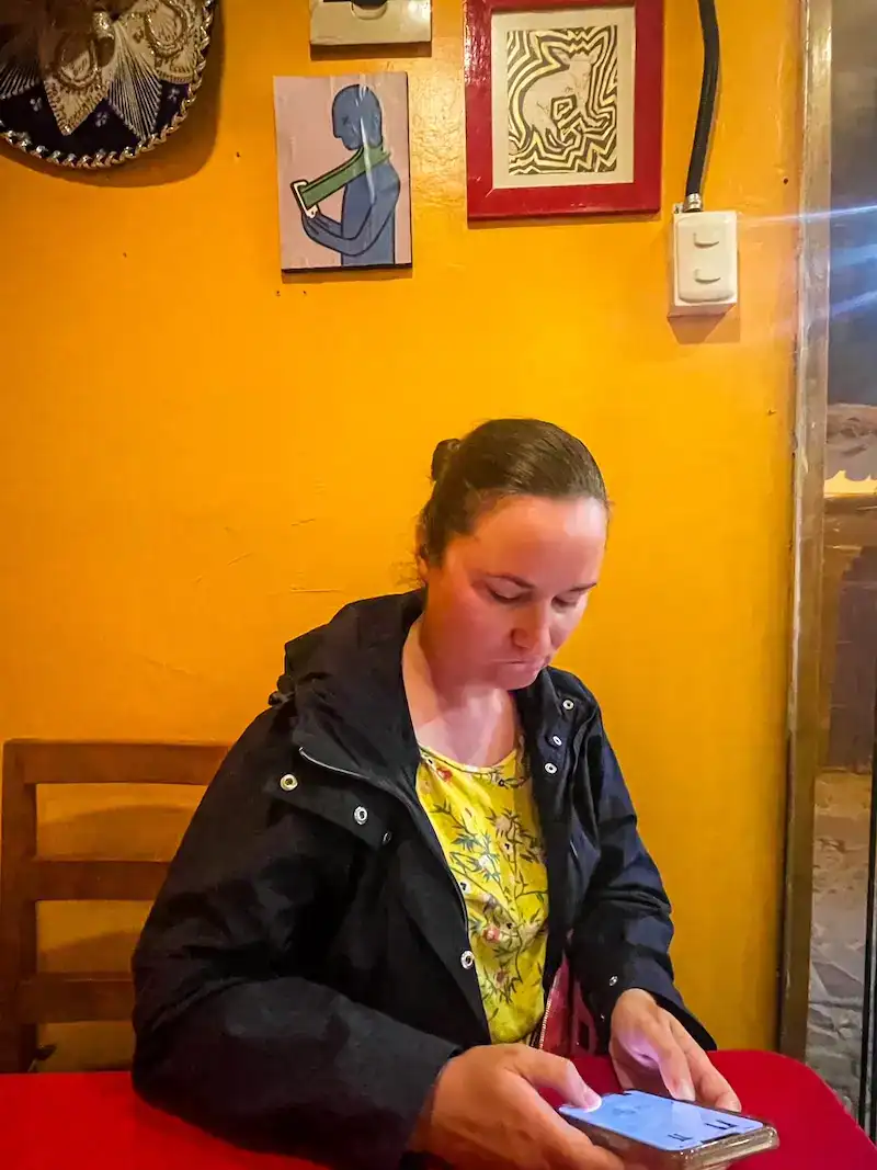 A woman uses her phone at a cafe in Cusco.