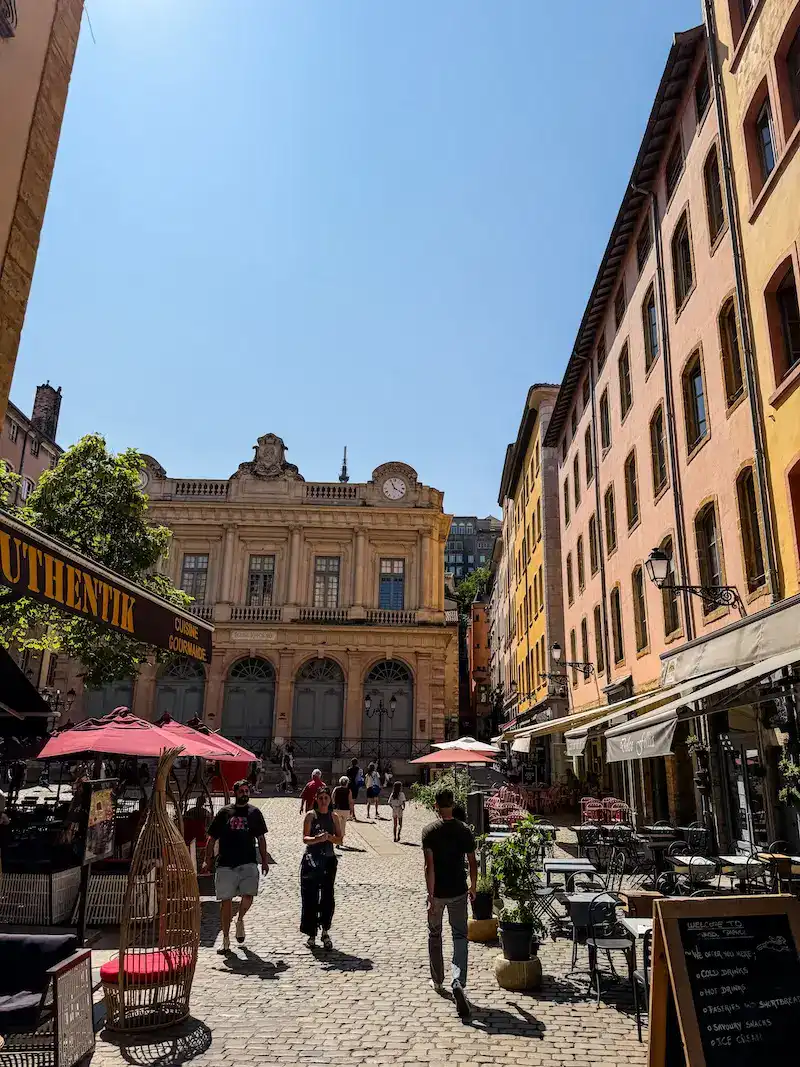 People walking through a sea of cafes of Lyon.