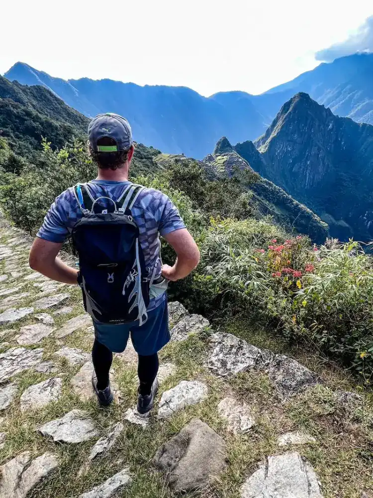 A man poses at the top of Machu Picchu.