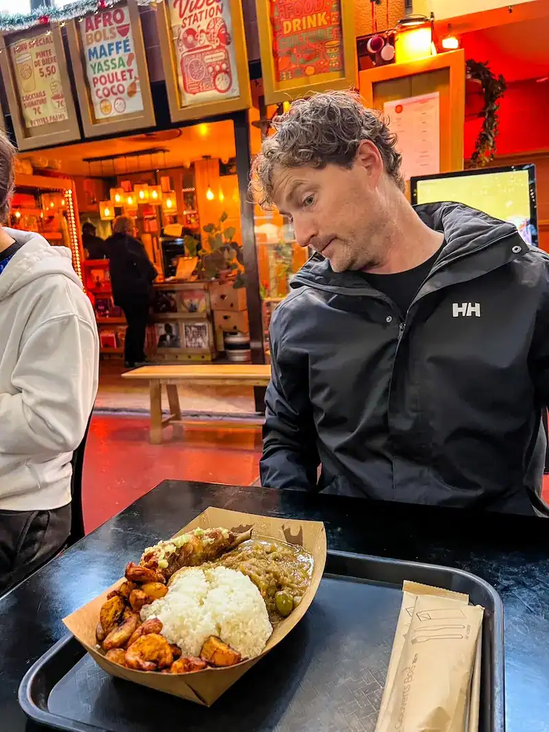 A man eats African food in a market hall in the 10th, considered by some to be the worst arrondissement in Paris.