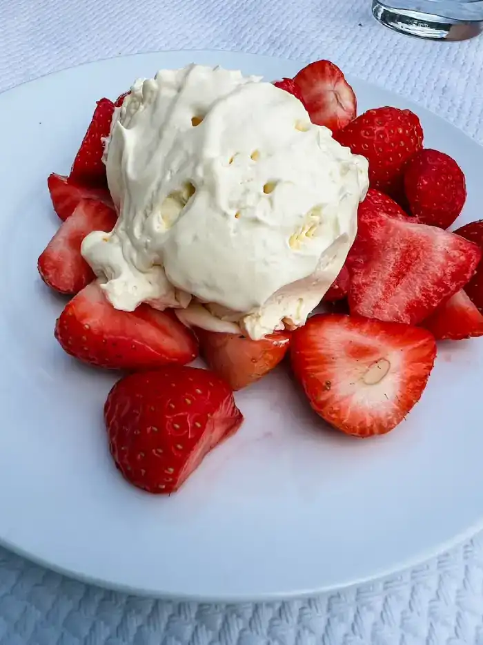 A plate of strawberries and Chantilly cream in Chantilly from Paris
