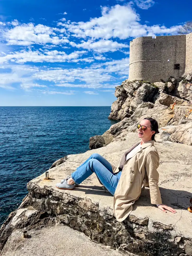 A woman poses near a beach in Dubrovnik.