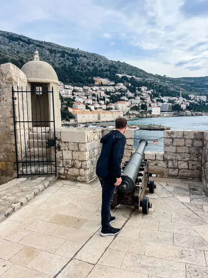 A man stands at a cannon in Dubrovnik.